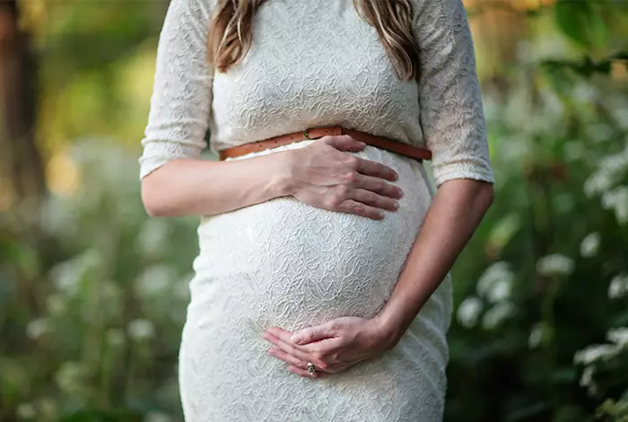 Schwangere Frau hält ihren Babybauch